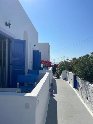 a row of white buildings with blue chairs on a sidewalk at Melina Hotel in Fira