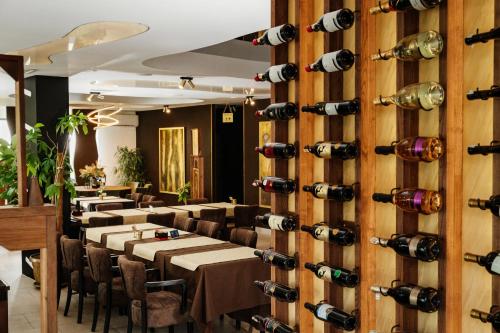 a dining room with tables and wine bottles on the wall at Edemus - Motel & Restaurant in Maglaj