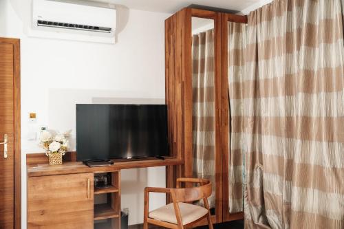 a living room with a television and a chair at Edemus - Motel & Restaurant in Maglaj
