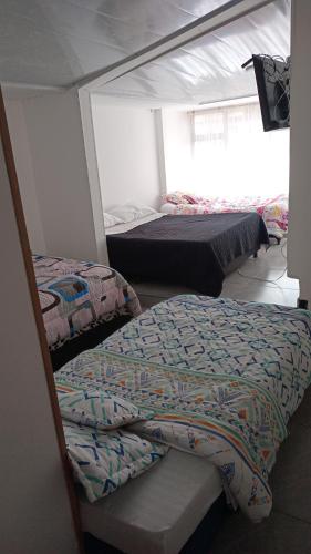 a bedroom with two beds and a window at Hotel la 15 in Chiquinquirá