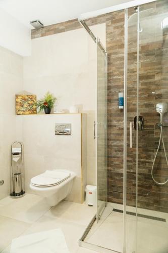 a bathroom with a toilet and a shower at Edemus - Motel & Restaurant in Maglaj
