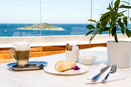 a table with a plate of food and a cup of coffee at Sirene Luxury Hotel Bodrum in Yalıkavak