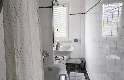 Un baño blanco con lavabo y ducha. en Apartment E - feel good, en Leipzig
