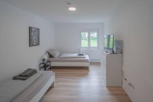 a white room with a bed and a tv in it at Gäste- und Monteurwohnung in Schramberg mit Parkplatz, WLAN, Küche bis 6 Personen - SCH02 in Schramberg