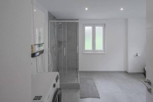 a white bathroom with a shower and a window at Gäste- und Monteurwohnung in Schramberg mit Parkplatz, WLAN, Küche bis 6 Personen - SCH02 in Schramberg
