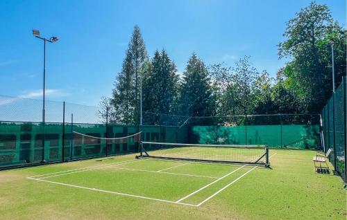 a tennis court with a net on top of it at Gorgeous Home In Väversunda With House Sea View in Väversunda