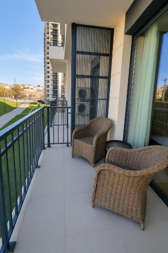 two wicker chairs sitting on the balcony of a building at Waterfront Cosy Studio Nest in Sajmište