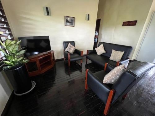 a living room with couches and a flat screen tv at Vale Kau in Nadi