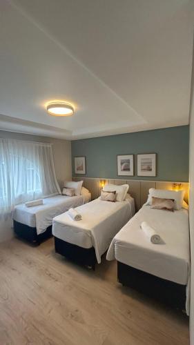 a hotel room with two beds in a room at Hotel VillaReal Guaratuba - Caieiras in Guaratuba