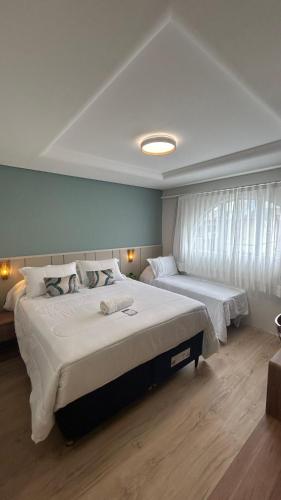 a bedroom with two beds and a window at Hotel VillaReal Guaratuba - Caieiras in Guaratuba