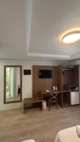 a living room with a desk and a mirror at Hotel VillaReal Guaratuba - Caieiras in Guaratuba