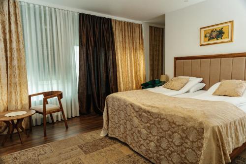 a hotel room with two beds and a chair and a window at Edemus - Motel & Restaurant in Maglaj