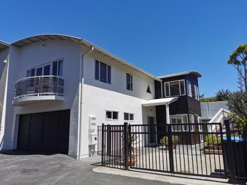 a white house with a black gate at Lilypad of Three Kings - Family friendly w Kitchen & Parking in Auckland