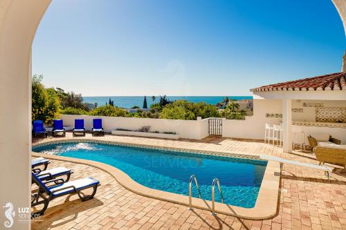 a swimming pool with chairs and a view of the ocean at 180 degree Ocean Views, Pure Paradise in Luz