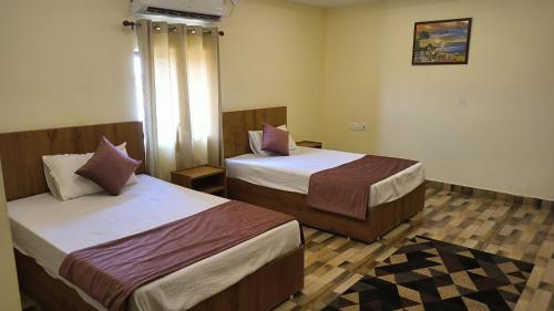 a hotel room with two beds and a window at hill mountain hotel in Khatīma