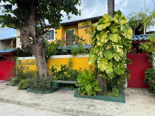 a yellow house with a bench in front of it at Pousada Leão in Maceió