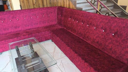 a red couch sitting on top of a table at hill mountain hotel in Khatīma