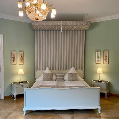 a bedroom with a large white bed with two night stands at Kavaliershaus neben Schloss Rauenstein in Rauenstein