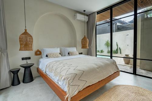 a bedroom with a large bed and a large window at Your Romantic Mediterranean Villa in Canggu in Dalung