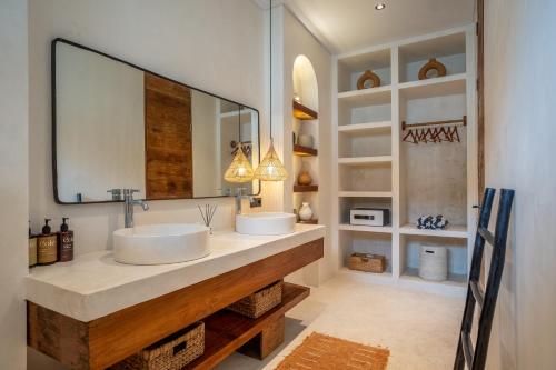 a bathroom with two sinks and a large mirror at Your Romantic Mediterranean Villa in Canggu in Dalung