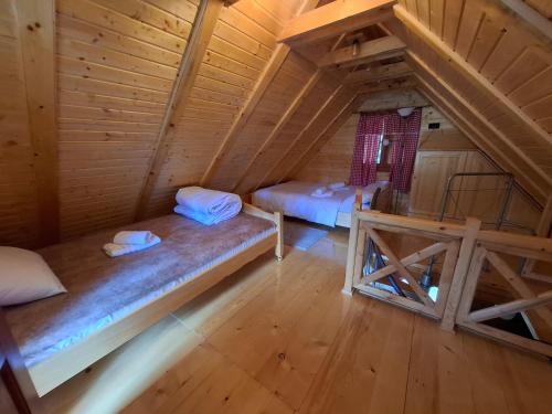 a room with two beds in a wooden cabin at Tvoja Kućica Za Beg in Banjska