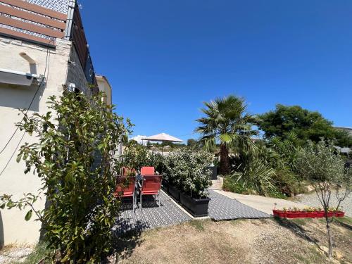 a patio with a table and chairs in a yard at Villa Héliopolis in Ventiseri