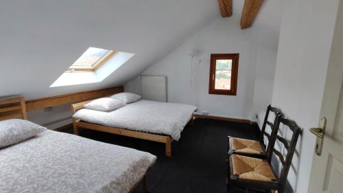 ビュッサンにあるDuplex avec vue au centre de Bussangのベッド2台と窓が備わる屋根裏部屋です。