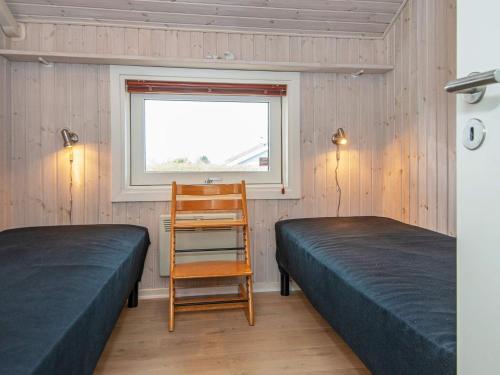 a bedroom with two beds and a chair and a window at 6 person holiday home in Nordborg-By Traum in Nordborg