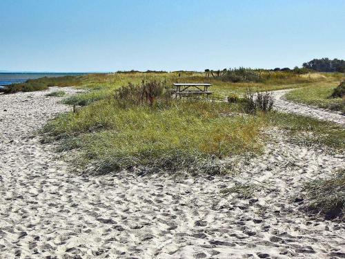 a picnic table sitting on a beach near the ocean at 6 person holiday home in Nordborg-By Traum in Nordborg