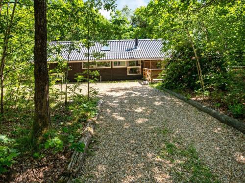 a cabin in the woods with a gravel driveway at 4 star holiday home in Ansager in Ansager