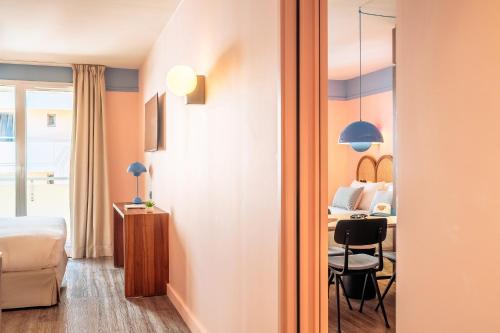 a bedroom with a bed and a table with a chair at RockyPop Marseille Hôtel in Marseille