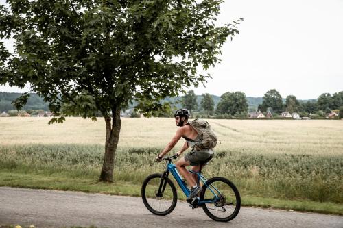 a man riding a bike down a road at Amenity Hotel & Resort Česká Kanada in Nová Bystřice