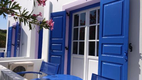 a blue door on a building with a table and chairs at Melina Hotel in Fira