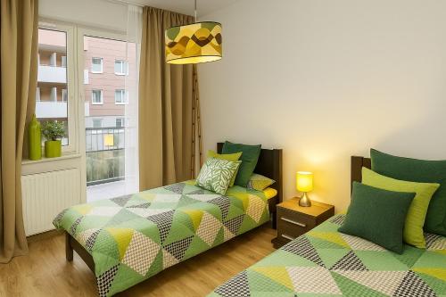 a bedroom with two beds and a window at TK Apartments Spiżowa in Wrocław