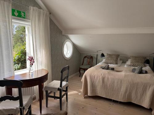 a bedroom with a bed and a table and a window at Folk och Fä in Grisslehamn