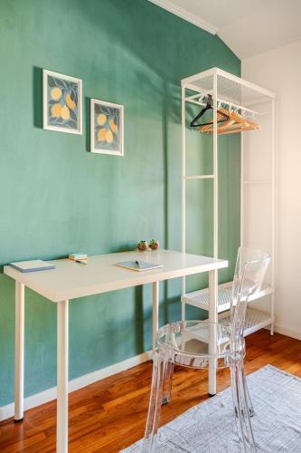 a white desk in a room with a green wall at Piazza San Giacomo - Attico su due livelli in Udine