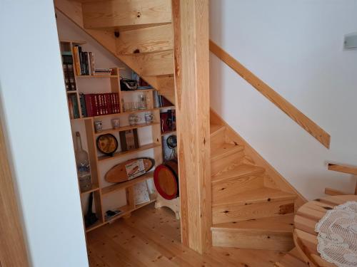 a wooden staircase in a room with a book shelf at Tvoja kućica za beg 2 in Plešin
