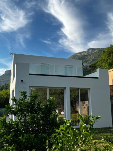 a white house with mountains in the background at House in Nature Milić in Čanj
