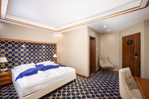 a bedroom with a bed and a desk and a chair at Hotel Central in Nyíregyháza