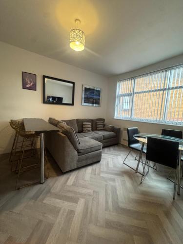 a living room with a couch and a table at The Bake Apartment - 5 bedroom Large Apartment sleeps up to 16 person in Newcastle upon Tyne