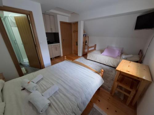 a small bedroom with two beds and a table at Tvoja kućica za beg 2 in Plešin