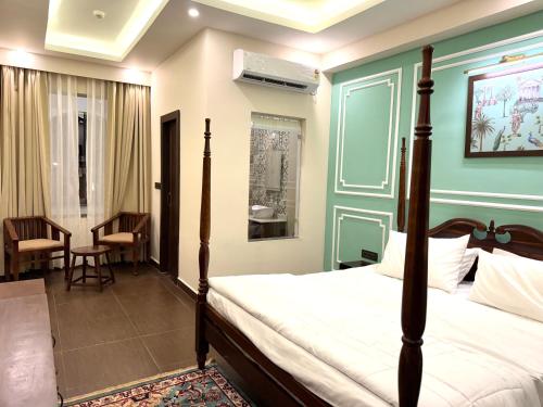- une chambre avec un lit et une chambre avec une chaise dans l'établissement Rambagh Resort by Stotrak, Gwalior, à Gwalior
