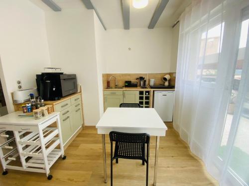 a kitchen with a white table and some chairs at Studio Cosy, Rénové, Ecrin de calme & confort in Céret