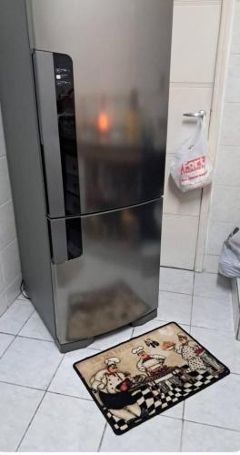 a kitchen with a rug next to a refrigerator at APARTAMENTO KOBRASOL - Bem localizado in São José