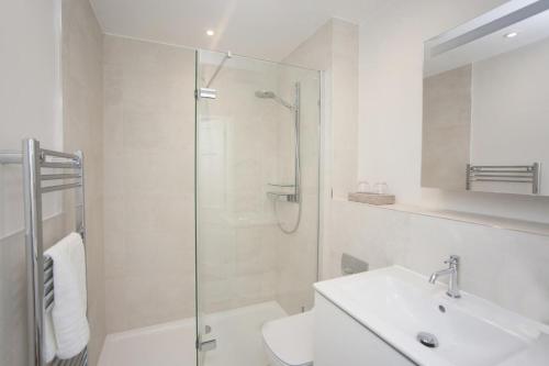 バースにある2 Bed in Bath oc-bhr42のシャワーと洗面台付きのバスルーム
