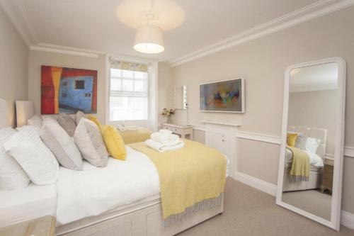 バースにある2 Bed in Bath oc-bhr42のベッドルーム1室(白い枕と鏡付きのベッド1台付)