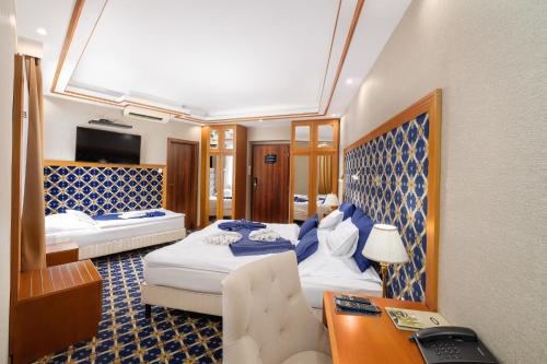 a hotel room with two beds and a desk at Hotel Central in Nyíregyháza