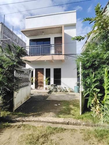 a white house with a balcony on top of it at Yannas transient house in Roxas City