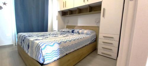 a small bedroom with a bed and a cabinet at Affittimoderni Trinita D Agultu - La Splendida in Isola Rossa