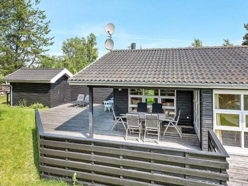 a wooden deck with a table and chairs on it at 4 star holiday home in Ålbæk in Ålbæk